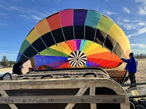 a person holding a colorful hot air balloon