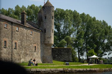 a castle with a clock tower in front of a brick building