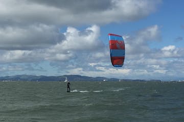 a man going kitesurfing in a large body of water