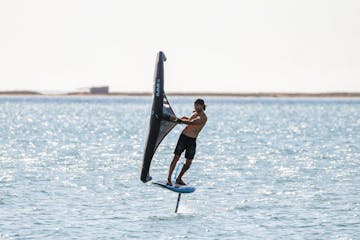 a man riding a board on a body of water