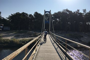 a man biking across a bridge