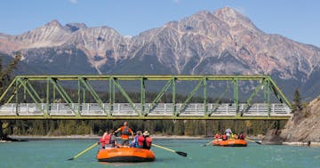 a group of people riding a raft on the Athabasca River in Jasper, Canada