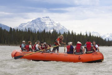 a group of people riding on a boat on the Athabasca River in Jasper, Canada