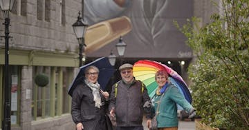 a man and a woman walking down a street holding an umbrella
