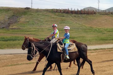 a little boy and girl doing their horseback riding lessons with sunshine and daydreams horseback riding in norco, california