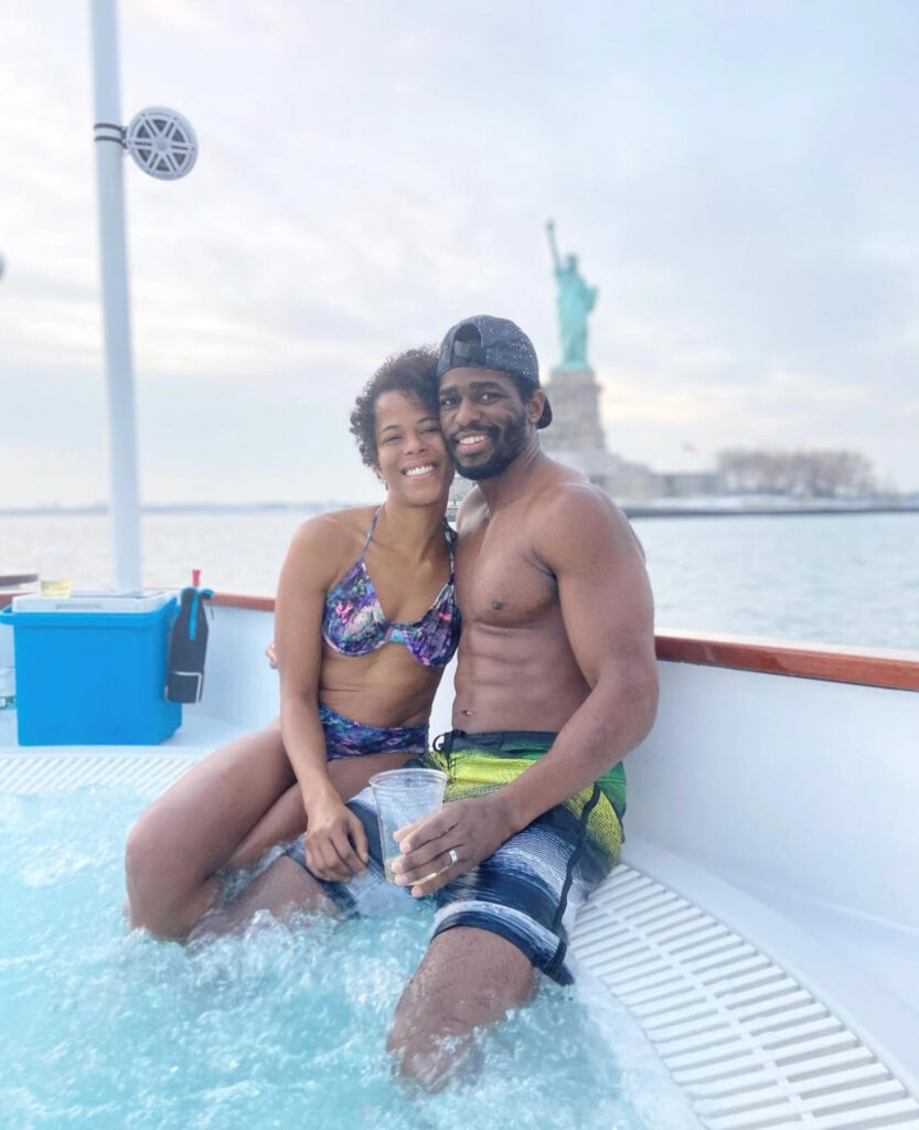 Man and woman in hot tub in front of the statue of liberty