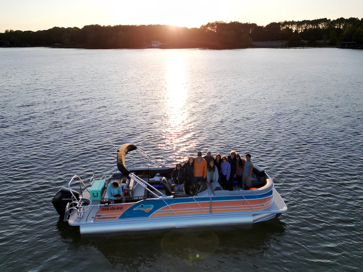 a group of people aboard carolina cruising charters' 25' ultimate luxury tritoon in lake norman, north carolina