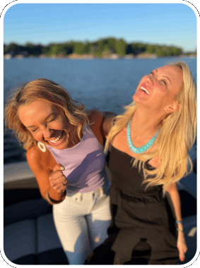 two girls having the time of their lives during their sunset cruise aboard carolina cruising charters' boat rental in lake norman, north carolina