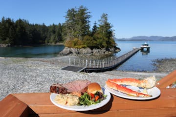 food on a picnic table in front of a lake