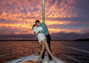 a couple kissing in front of a sunset