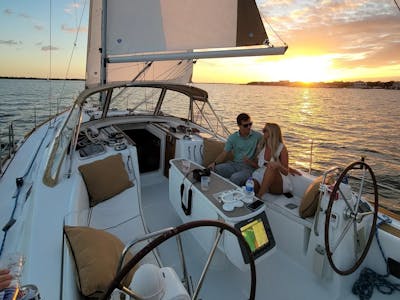 a couple on a sailboat at sunset