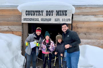 a group of people smiling for the camera on a self guided historic snowshoe tour with country boy mine in breckenridge, colorado