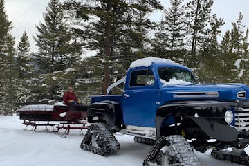 a man posing for the camera on a monster truck sleigh tour with country boy mine in breckenridge, colorado