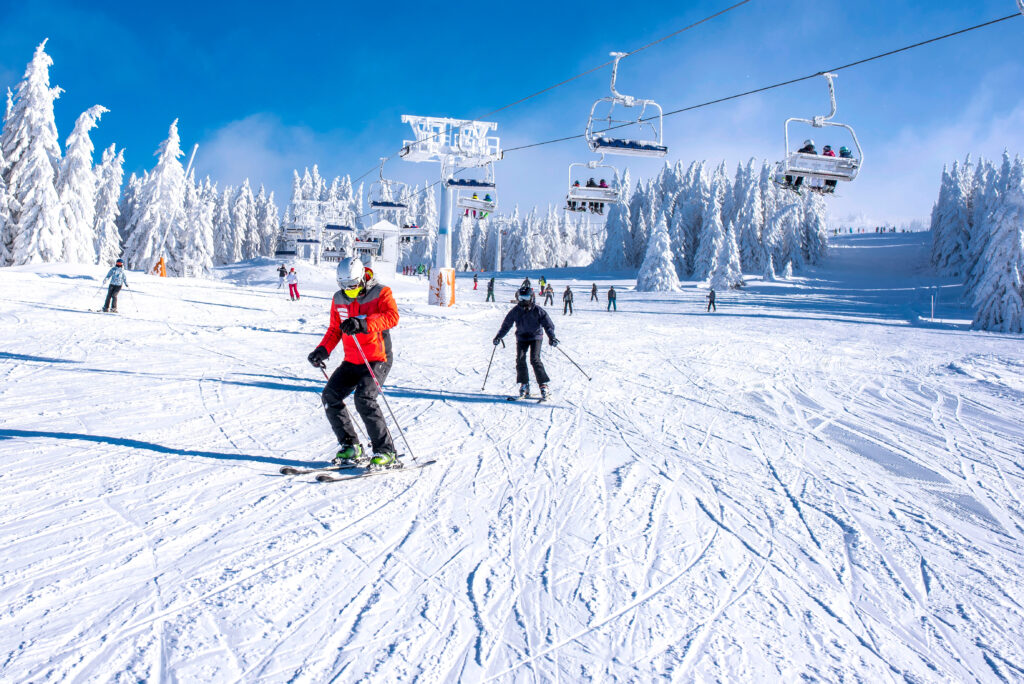 a group of people riding skis down a snow covered slope