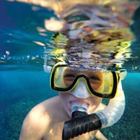 a man wearing sunglasses taking a selfie in a body of water