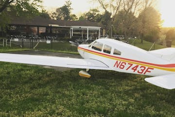 a small airplane sitting on top of a grass covered field