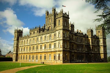 a large clock tower in front of Highclere Castle