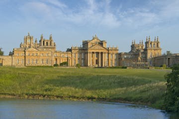 a castle surrounded by a body of water with Blenheim Palace in the background