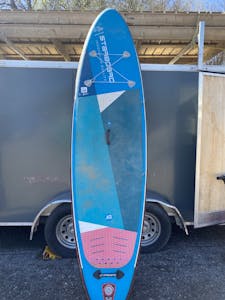 a blue SUP leaning on the side of a box trailer
