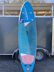 a blue SUP leaning on the side of a box trailer