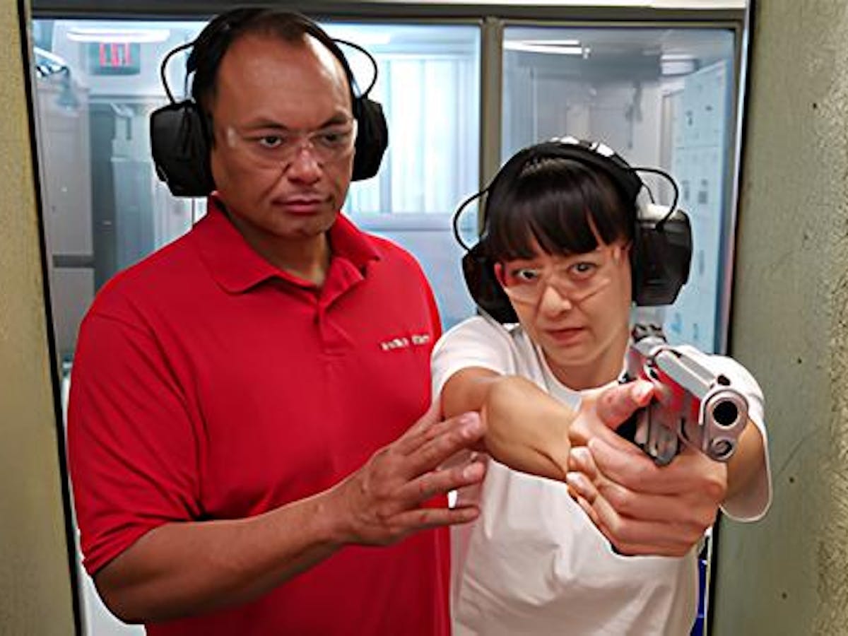 a man teaching a woman how to fire a gun at 808 gun club in honolulu, hawaii
