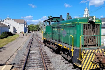 a green train that is sitting on a railroad track
