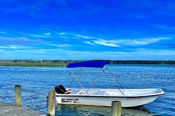 a blue and white boat sitting next to a body of water