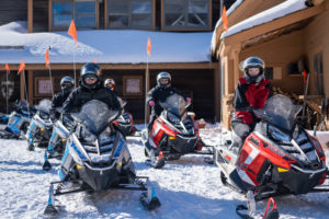a snowmobile tour group waits to ride on the best snowmobile tour in the east, snowmobile vermont.