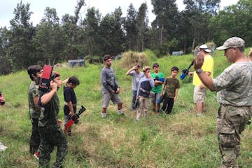 A group being instructed on how to use Laser tag guns outdoors in Hawaii