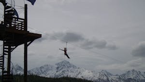 a person flying through the air on a snow covered mountain