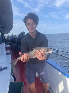 Martin Garrix holding a fish on a boat
