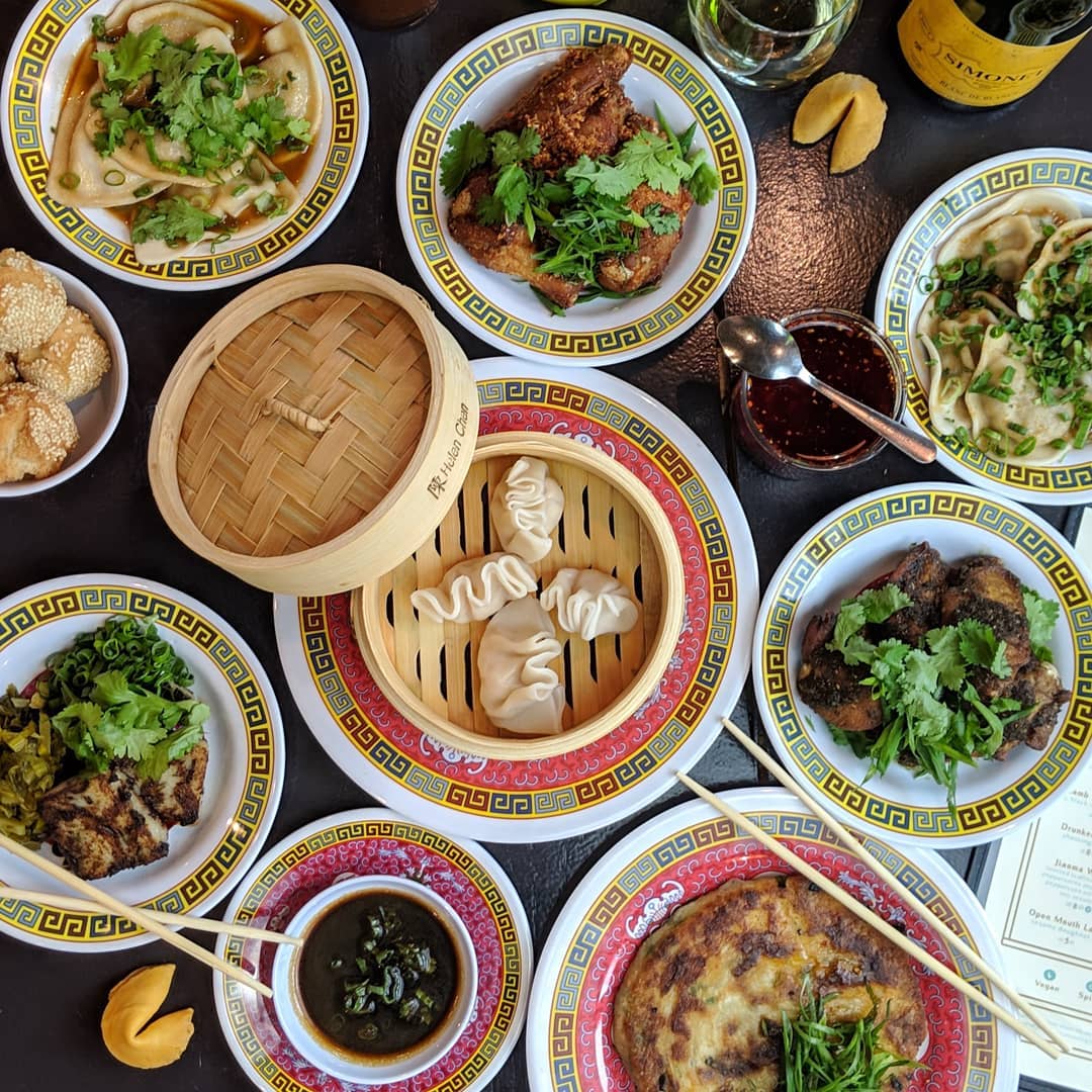 a group of people sitting at a table with a bowl of salad